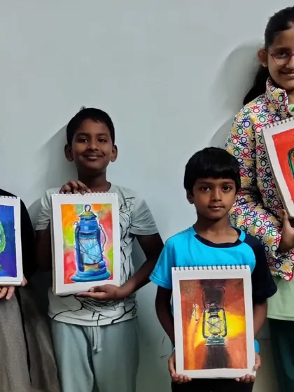 A group of proud students holding up their bright and colourful lantern drawings.