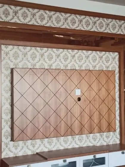 A damask pattern wallpaper used to frame a wooden TV unit. This is a creative way to use wallpaper to highlight architectural features.
