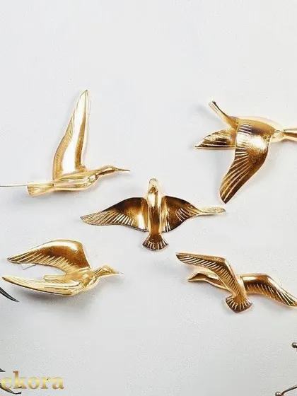 These flying metal birds are finished in a polished gold, catching the light beautifully.