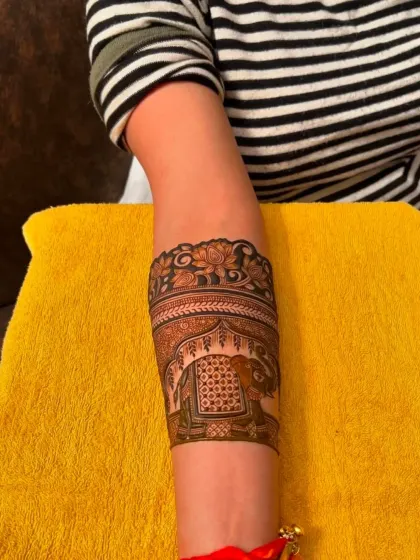 A work-in-progress shot of a beautiful armband featuring a royal elephant. You can see the fresh henna paste before it dries and stains the skin.