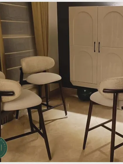 A set of three custom-made bar stools with curved wooden backs and upholstered seats. We designed these for a client's home bar, focusing on both comfort and a refined, modern aesthetic.