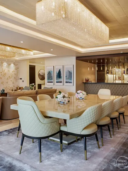 In our Kingfisher Tower project, the dining area is part of a large, open-plan space that includes a living room and a full bar. The onyx dining table and quilted leather chairs are positioned under a large crystal chandelier, creating a zone of formal elegance perfect for hosting.