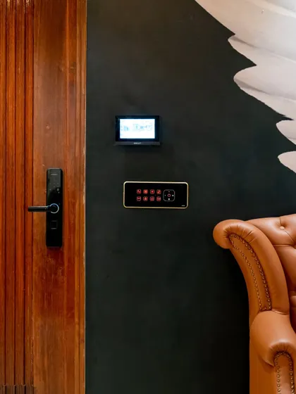A full entrance setup with a smart lock, video monitor, and control panel against a dark, dramatic wall, creating a powerful first impression.