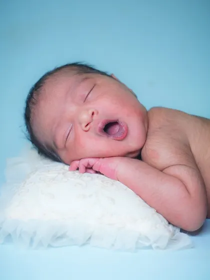 A tiny yawn from a sleepy newborn. Capturing these fleeting, natural moments is what makes each session unique and special.