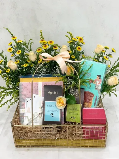 The perfect gift for a newly engaged couple. This hamper includes a fun 'Personal Pursuits' game, a bridal planner, and sweet treats, all set in a beautiful floral basket.