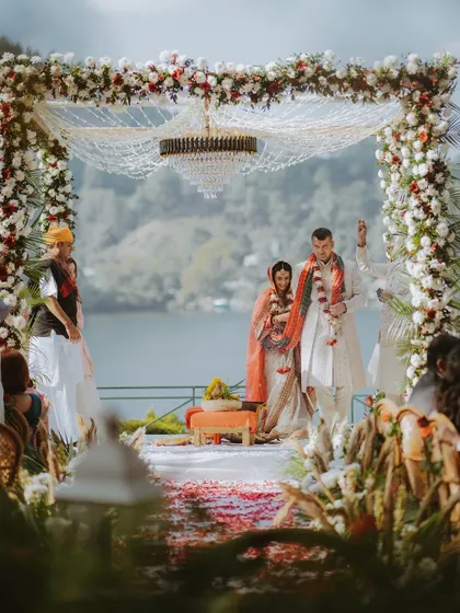 The wedding venue is more than just a backdrop; it's a character in your story. Here, a stunning lakeside mandap becomes the stage for a breathtaking Hindu ceremony, showcasing how I integrate grand locations into your wedding film.