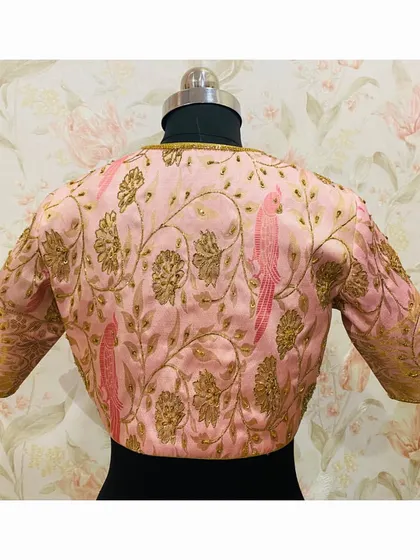The back of the pink blouse, featuring two embroidered parrots amidst a garden of flowers. A truly unique piece.