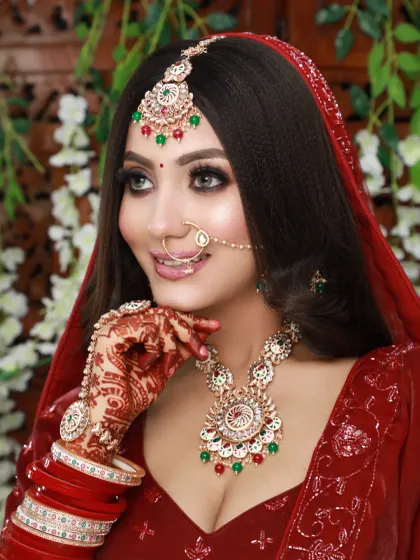 This look combines a traditional red lehenga with a fresh, modern makeup approach. The skin is luminous and the eyes are bright, creating a youthful and radiant bridal style.