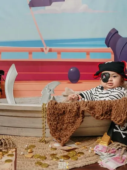 A baby pirate with an eye patch, surrounded by skulls and gold coins.