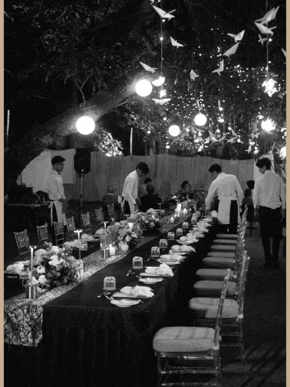 A black and white shot of the long dining table at the saree exhibition, with staff making final preparations.