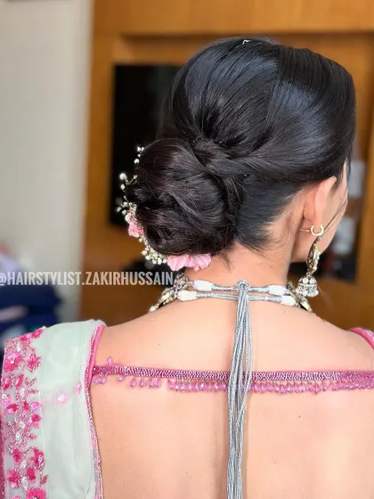 A back view of the low bun, showing the clean lines and secure placement of the flowers. This is a great example of a neat yet soft bridal updo.
