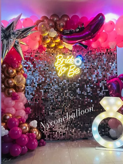 I designed this glamorous 'Bride to Be' party setup for a memorable celebration. It features a dazzling pink sequin wall, a custom neon sign, a light-up diamond ring prop, and a balloon arrangement in shades of pink and rose gold.