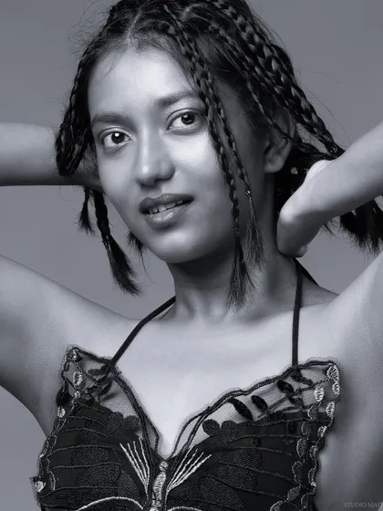 A black and white close-up, focusing on the model's face and braids.