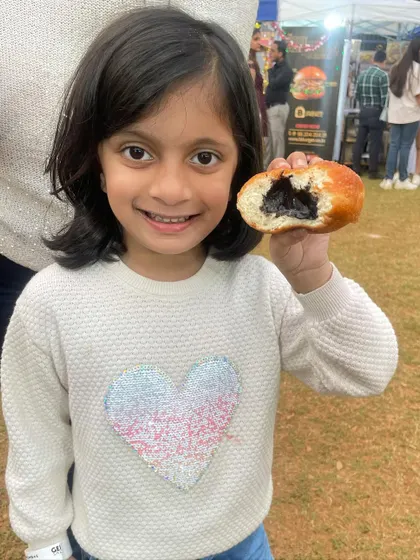 A happy smile and a half-eaten chocolate stuffed donut. This is what pure joy looks like at one of my pop-up stalls.