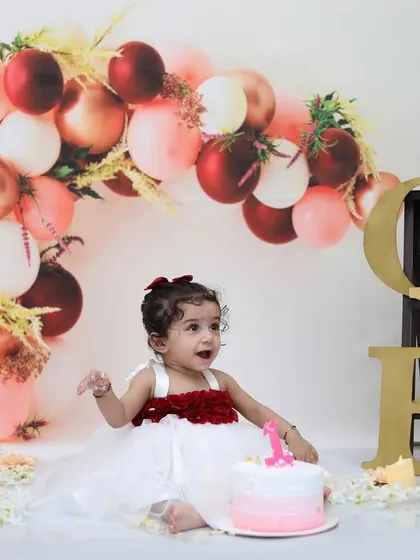 A classic first birthday portrait setup, featuring a beautiful balloon arch and a little girl ready to celebrate. This shows the elegant and styled side of my birthday sessions, captured before the cake smash fun begins.