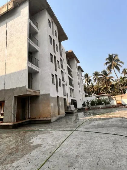 The exterior of the Goa project during construction, showing the building taking shape against a backdrop of palm trees.