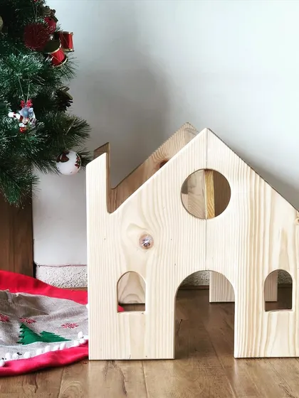 The front view of the house chair, showing the cute window and door cutouts. It’s handcrafted from natural pine wood and is completely baby-safe.