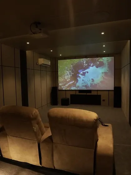 A view from the comfortable fabric recliners, showing the large screen and the simple, elegant interior design.