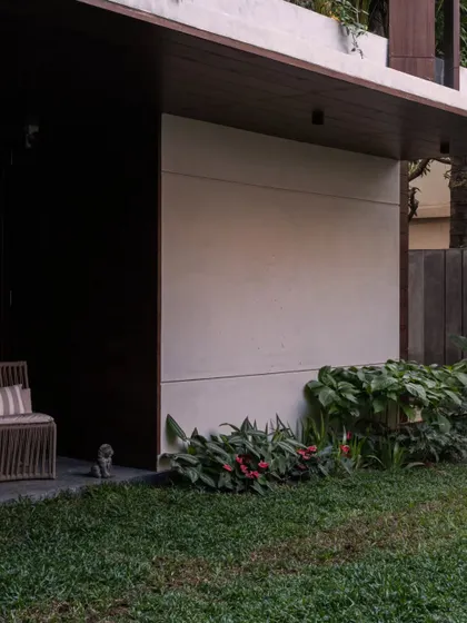 Another view of the home's exterior, where the simple material palette of cement and wood allows the lush greenery to be the star.