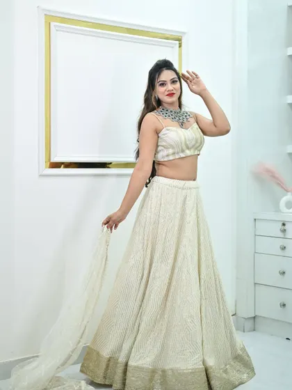 A model posing in the ivory chikankari lehenga, paired with a stunning modern diamond necklace.