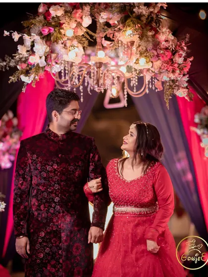 The couple sharing a sweet moment under a floral chandelier at their reception.