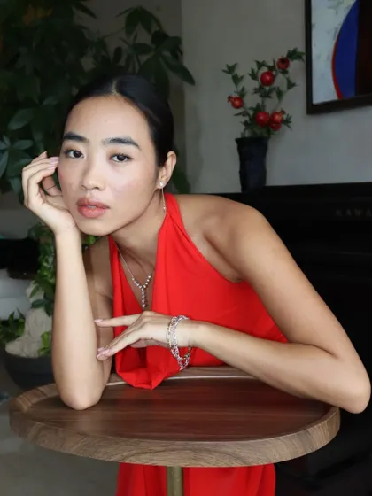 Let the neckline do the talking. This model showcases a delicate Y-shaped diamond necklace that perfectly complements a halter-neck dress for a look of effortless elegance.