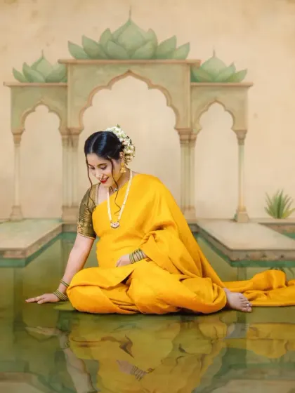 A serene and artistic portrait in our Ravi Varma inspired style. The mom-to-be is seated gracefully in a traditional yellow saree, creating a timeless masterpiece.