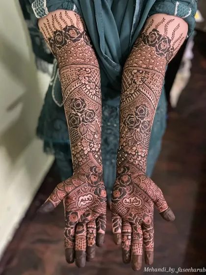 A clear, full view of the intricate bridal henna, showing how the patterns flow from the palm to the forearm.