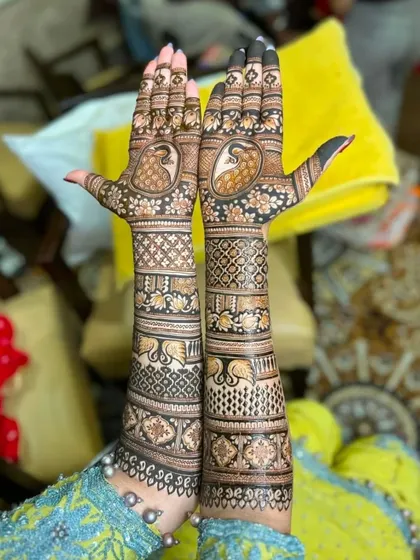 A full view of a traditional design with peacocks on the palms and elephants on the forearms.