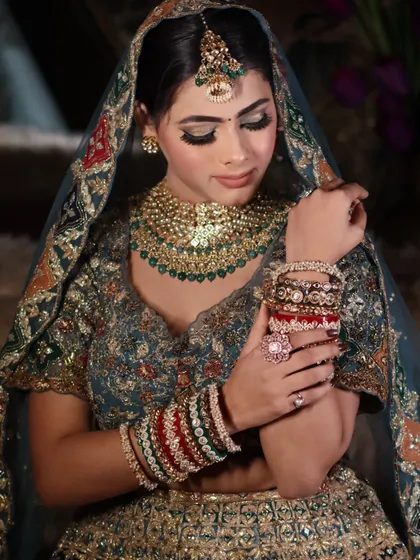 A close-up focusing on the bride's hands and bangles, with the beautifully done eye makeup in the background.