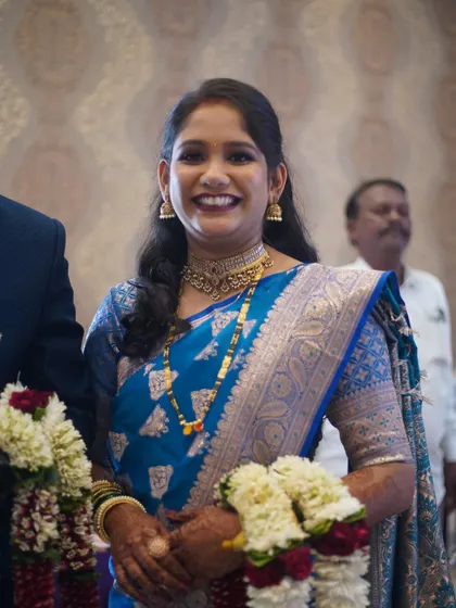 A bright, smiling portrait of the bride. Her makeup enhances her natural happiness and creates a memorable reception look.