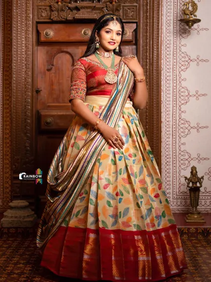 A full-length view of the multi-color leaf print half saree, showcasing its elegant drape and red border.