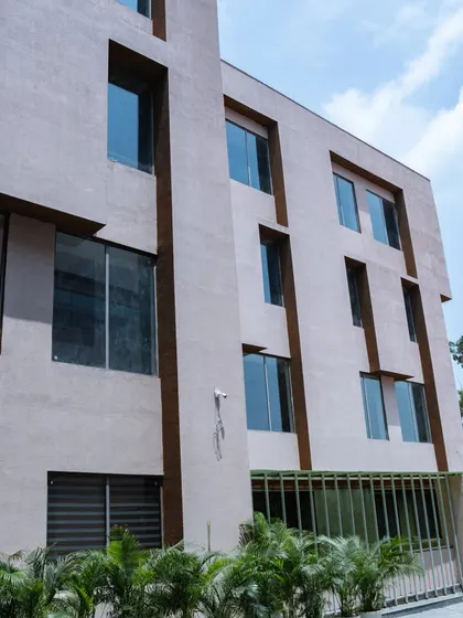 A look at another facade of the school, where recessed windows and contrasting brown accents create a sense of depth and architectural rhythm.
