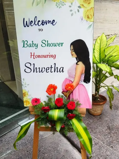 Another lovely welcome sign for a baby shower, this one for Shwetha. The fresh flower arrangement at the base adds an elegant touch.