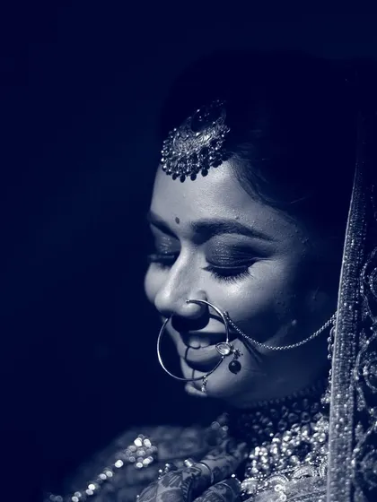 A smiling bride captured in a cool, blue-toned monochrome, highlighting her happiness.