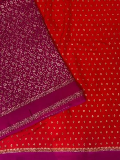A vibrant red Banarasi saree with all-over buttas, paired with a contrasting purple brocade blouse piece. This is a classic, "classy" combination that is perfect for celebrations.
