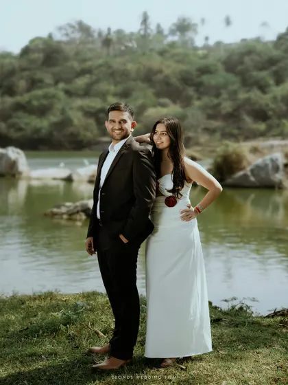 A classic couple portrait by the lake, showcasing their elegant outfits and confident poses against the natural scenery.