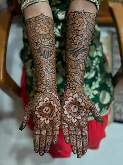The bride showing off her beautiful, personalized mehendi. The combination of the palm mandalas and the floral arm design is just perfect.