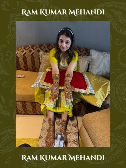 A full-length shot of a happy bride with her completed mehandi on hands and feet.