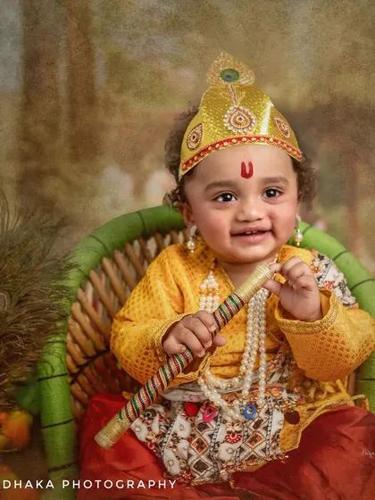 A happy little Krishna with his flute. The joy on his face is infectious, and the detailed costume and peacock feathers in the background complete this divine portrait.