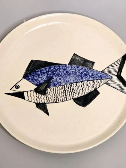 This sold plate features a stylized fish with geometric patterns. It was designed as a perfect wall decoration or a thoughtful housewarming gift.