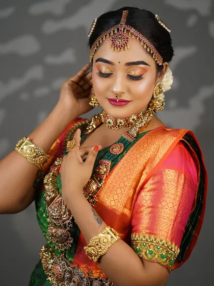 A side profile that gives a better view of the hairstyle and the intricate details of the earrings and necklaces.