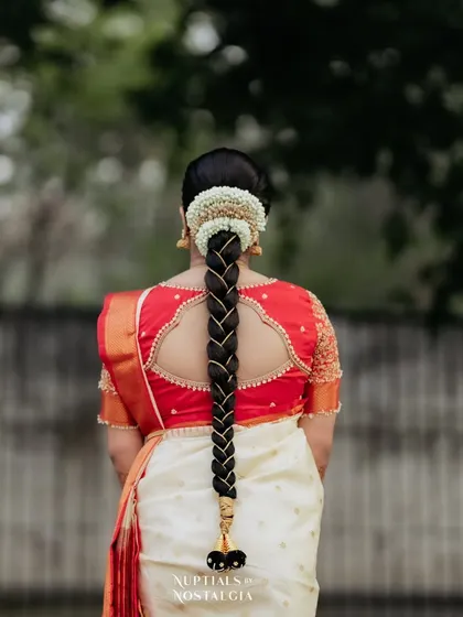 A view of the traditional bridal braid, adorned with gold accessories and fresh flowers, a hallmark of South Indian weddings.