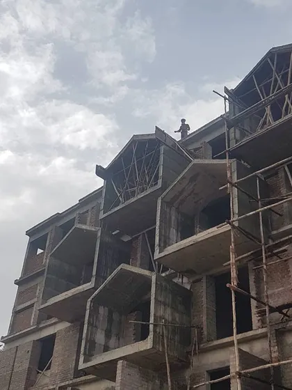 A view of an apartment building during the construction phase. This image reveals the concrete shell of the projecting balcony structures before the application of finishing materials.