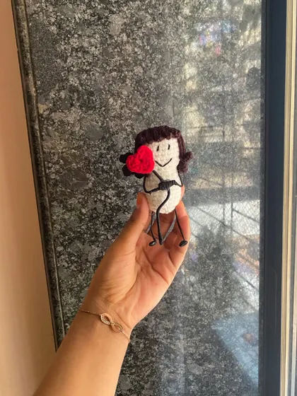 A simple and sweet message doll. This little figure holds a bright red heart, a perfect way to send a little bit of love to someone you care about.