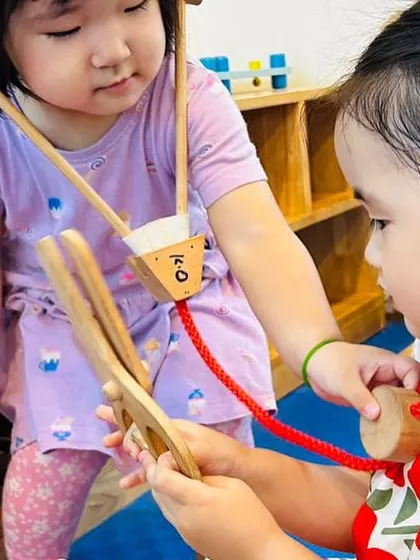 These two little "doctors" collaborate to use a toy stethoscope. Role-playing helps children develop empathy and practice caring for others.