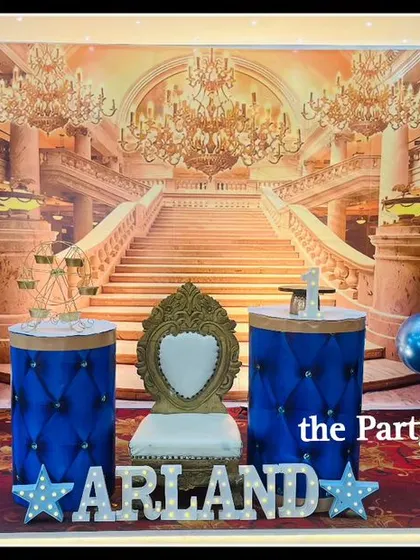 Prince Arland's birthday was a royal affair with this regal blue and gold theme. The decor includes a palace backdrop, a throne for the birthday boy, and elegant balloon columns.