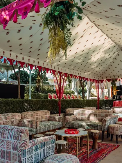 The lounge seating area for the Jaipur Haldi, featuring custom-printed sofas and traditional Rajasthani tents.