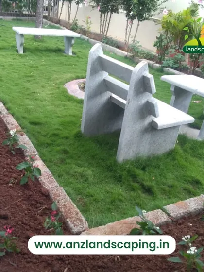 This garden design incorporates stone benches and tables directly into the lawn, providing durable and integrated seating for a park-like feel.