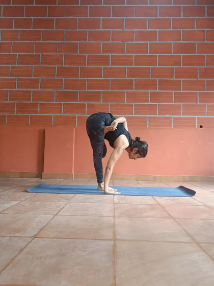 This is another view of Ardha Baddha Padmottanasana. This pose, from the Ashtanga tradition, requires balance, hip flexibility, and a deep forward fold.
